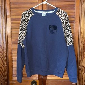 PINK navy blue crew neck sweatshirt with cheetah print sleeves.